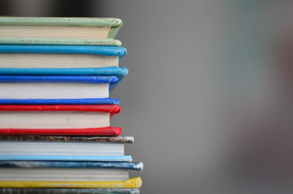A colorful stack of novels and books representing beginner-friendly English reading material