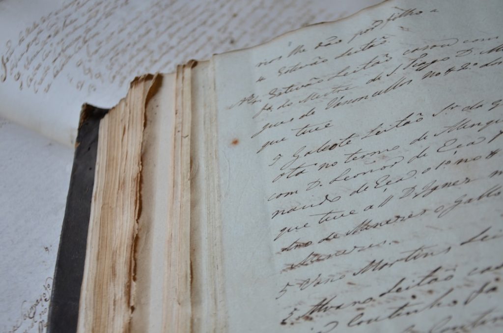 Close-up of aged handwritten manuscript pages — evoking centuries of literary tradition that the all-time great novels were built upon